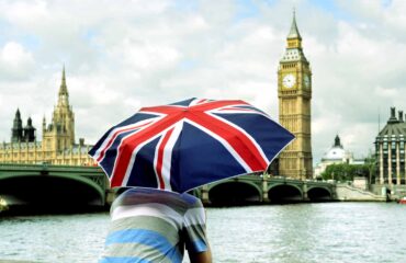 Big Ben and tourist with British flag umbrella in London